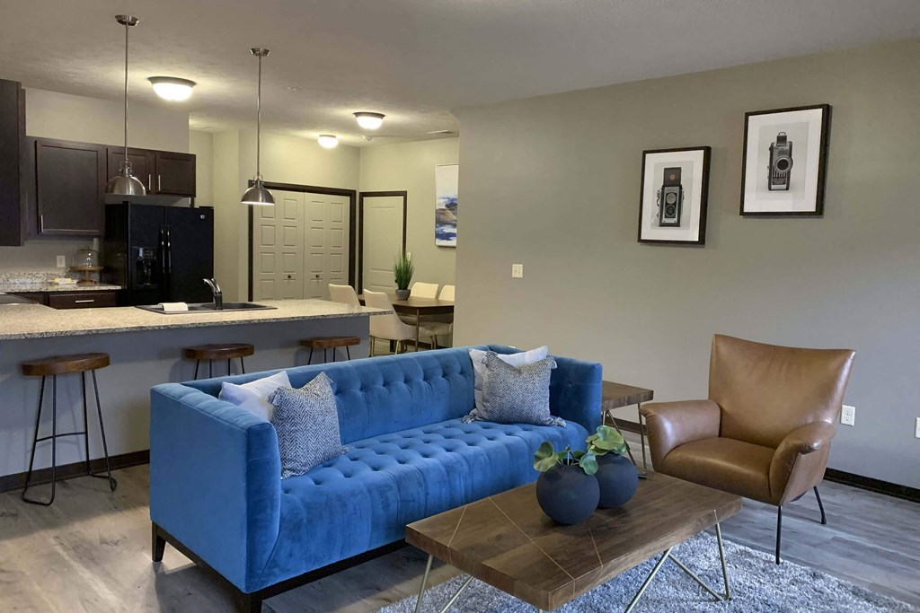 a blue couch in a living room next to a kitchen