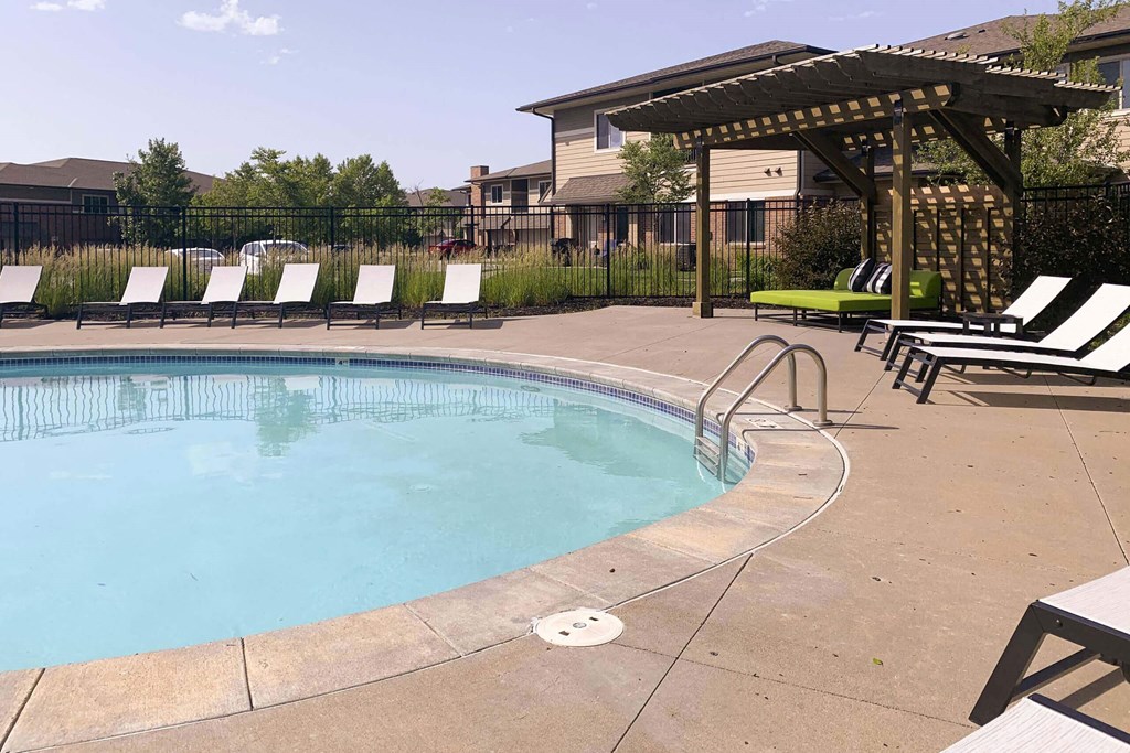 a resort style pool with lounge chairs and a gazebo