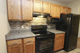 Renovated kitchen with granite counters and new appliances at The Northbrook