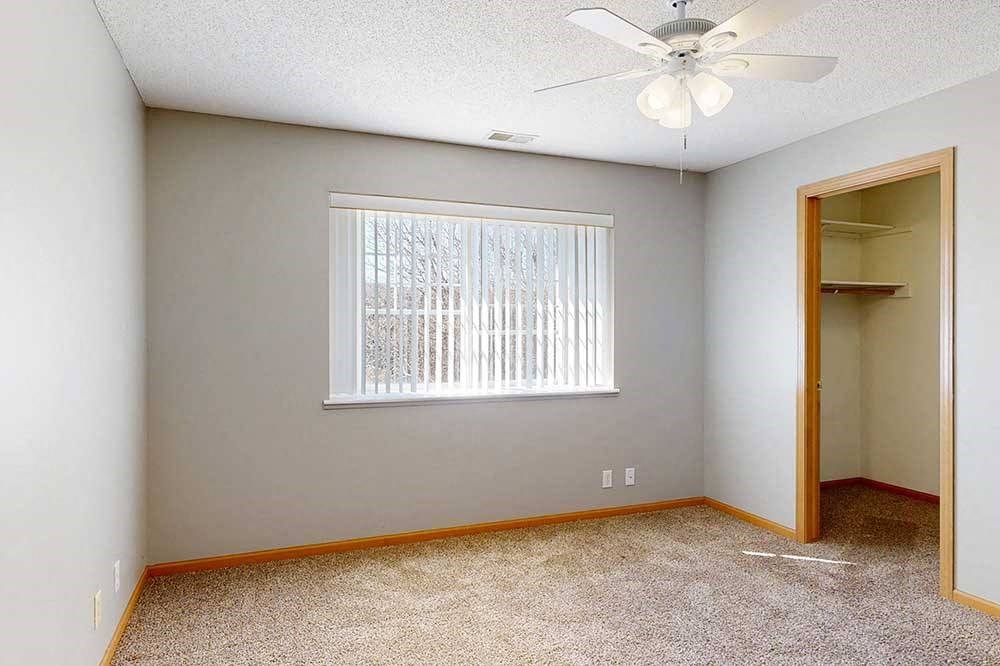 bedroom with a ceiling fan and a window with blinds