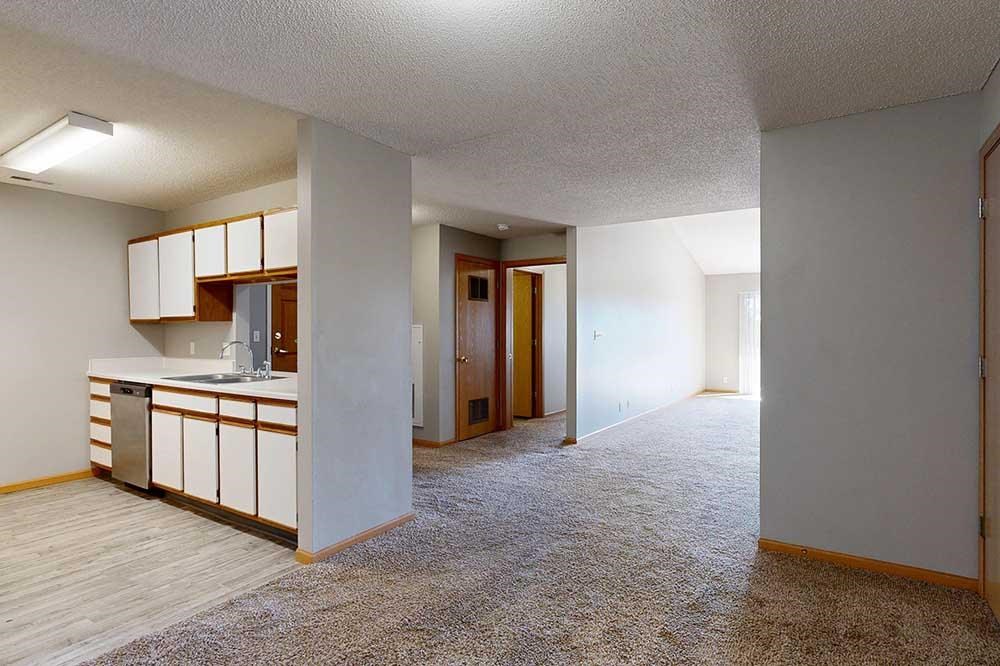 kitchen with white cabinets and hallway to living room