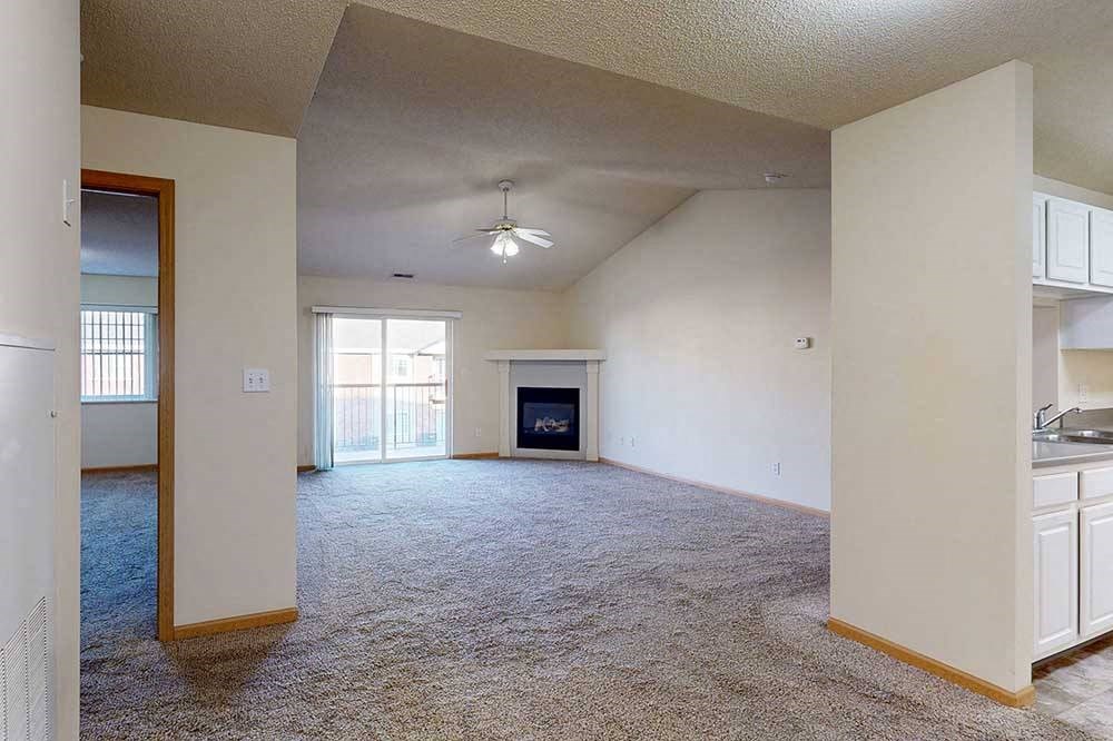 spacious living room with a fireplace and a ceiling fan