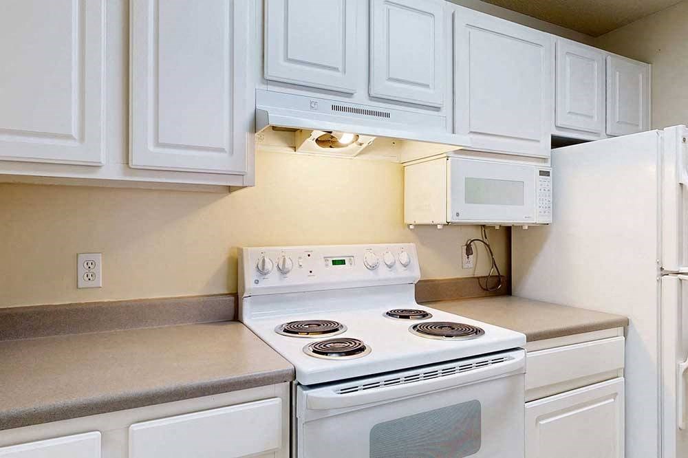 stove and oven in a kitchen with white cabinets