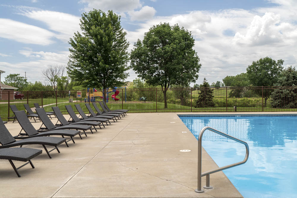 Large outdoor pool with lounge chairs at The Northbrook Apartments