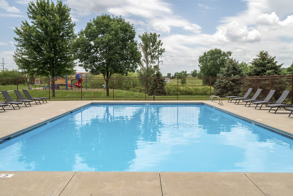 Large outdoor pool with lounge chairs at The Northbrook Apartments