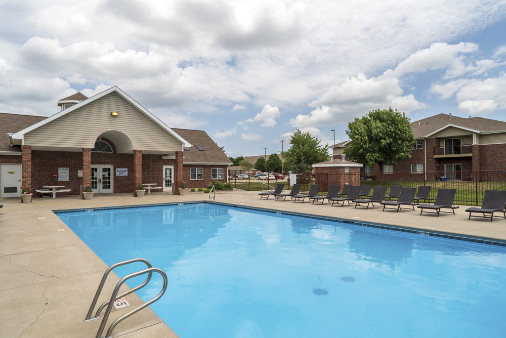 Large outdoor pool with lounge chairs at The Northbrook Apartments