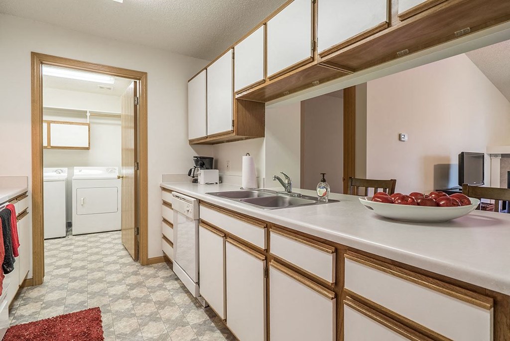 a kitchen with white cabinets and a sink      and a door