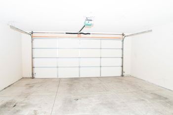 an empty garage with a white wall and a garage door