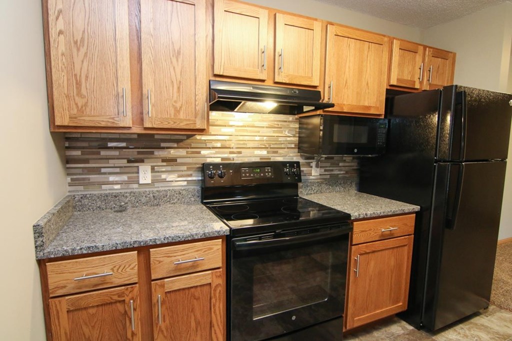 The Glacier renovated kitchen a kitchen with black appliances and granite counter tops