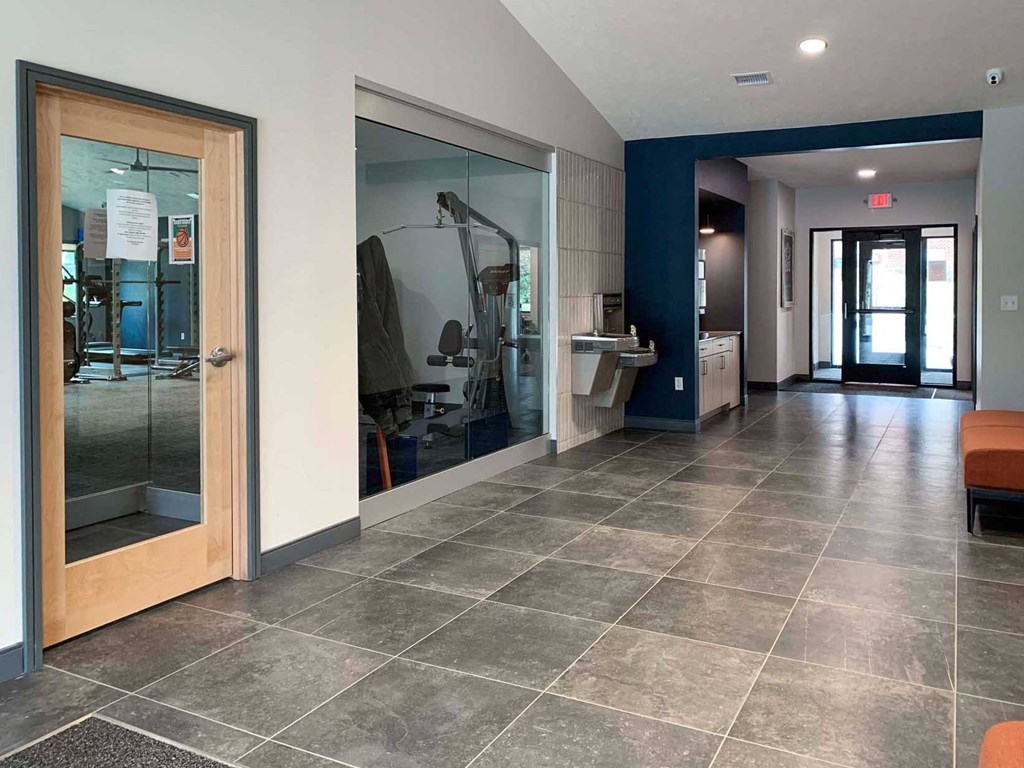 a view of a hallway with glass doors in an apartment clubhouse