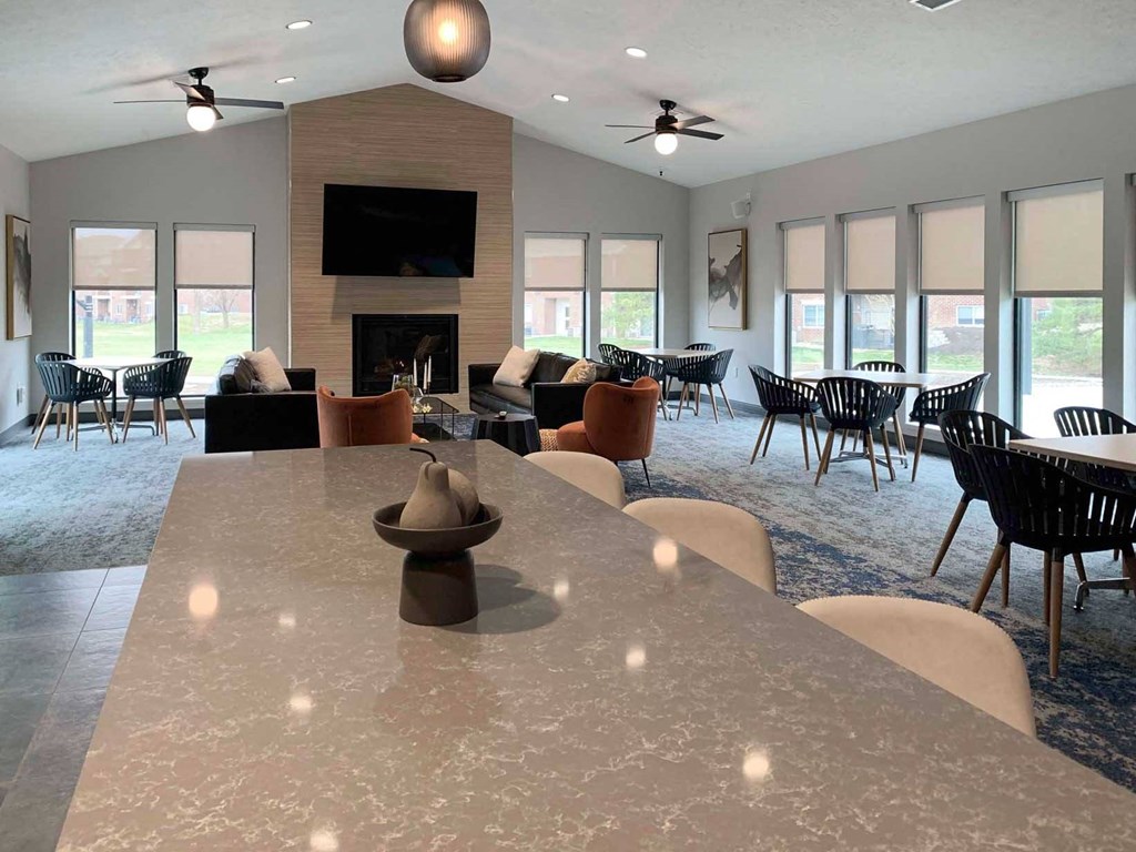 a gathering room with tables and chairs and a fireplace