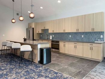 a kitchen with a long counter with bar seating