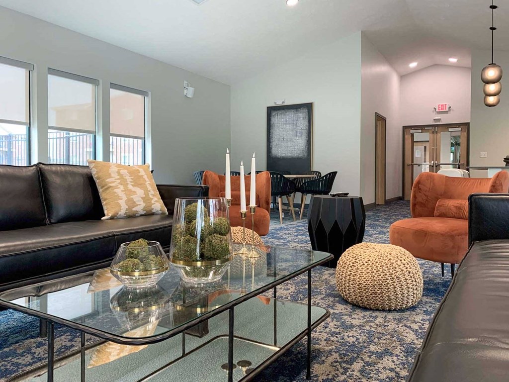 a clubhouse community room with couches and a glass table