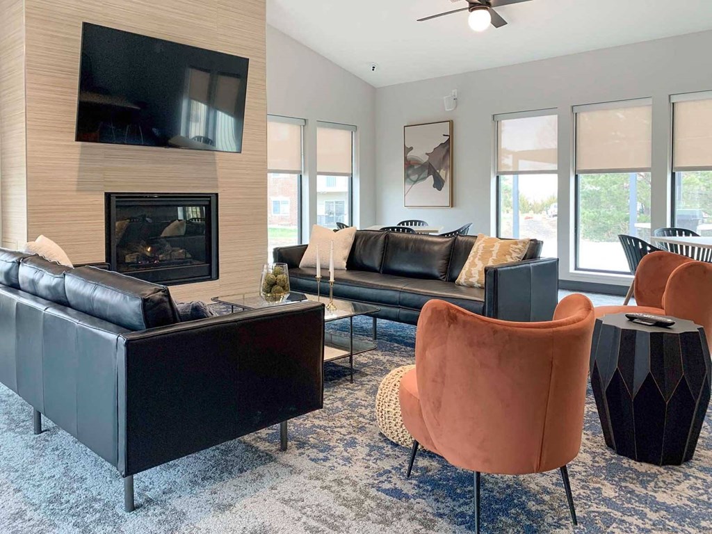a clubhouse living room with leather furniture and a fireplace