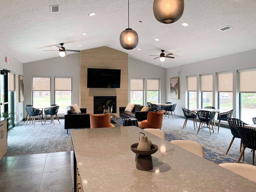 a large clubhouse with a table and chairs and a fireplace