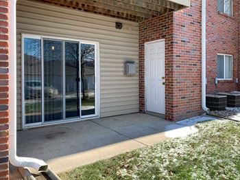 a patio off a brick building with a sliding glass door