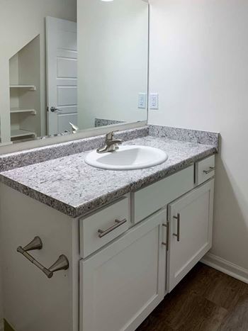 a bathroom with a white vanity sink overhead lighting