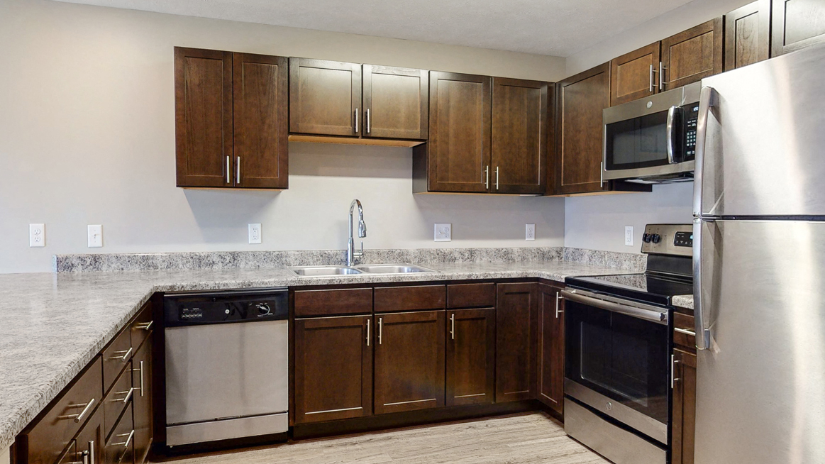 Renovated kitchen with granite counters and new appliances at Northridge Heights Apartments