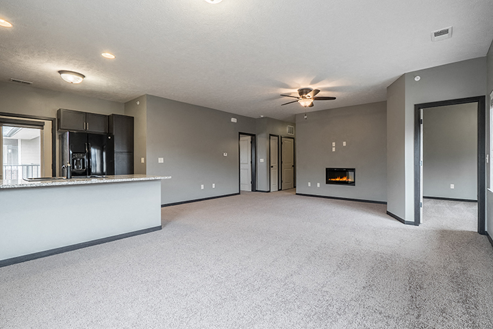 Interiors-Living room with electric fireplace and ceiling fan at The Villas of Omaha at Butler Ridge in Omaha Nebraska