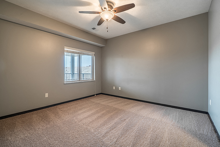 Interiors- Bedroom with ceiling fan and abundant natural lighting at the Villas of Omaha at Butler Ridge in Omaha Nebraska
