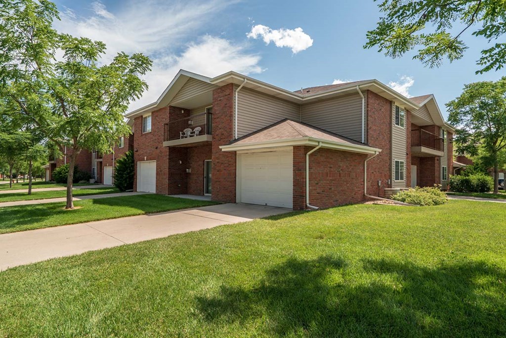 A large brick apartment building with a garage and a driveway.