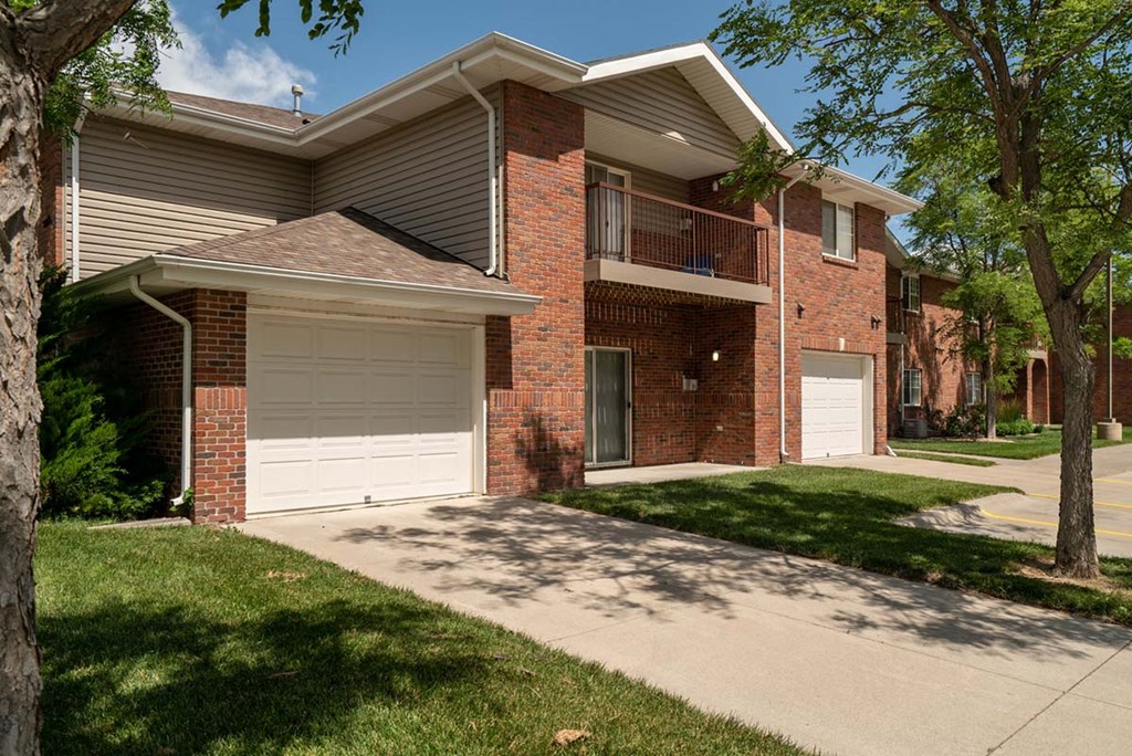 A two-story brick apartment building with a garage.