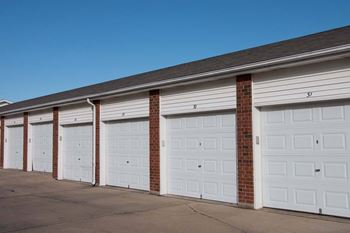 A row of white garage doors are closed
