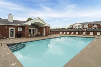 Resort style swimming pool with sun tanning loungers at Ridge Pointe Villas in South Lincoln Nebraska