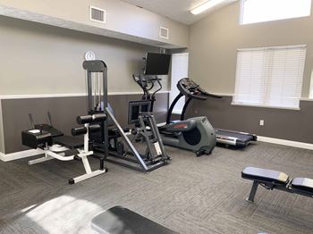 an apartment gym with weights and cardio equipment