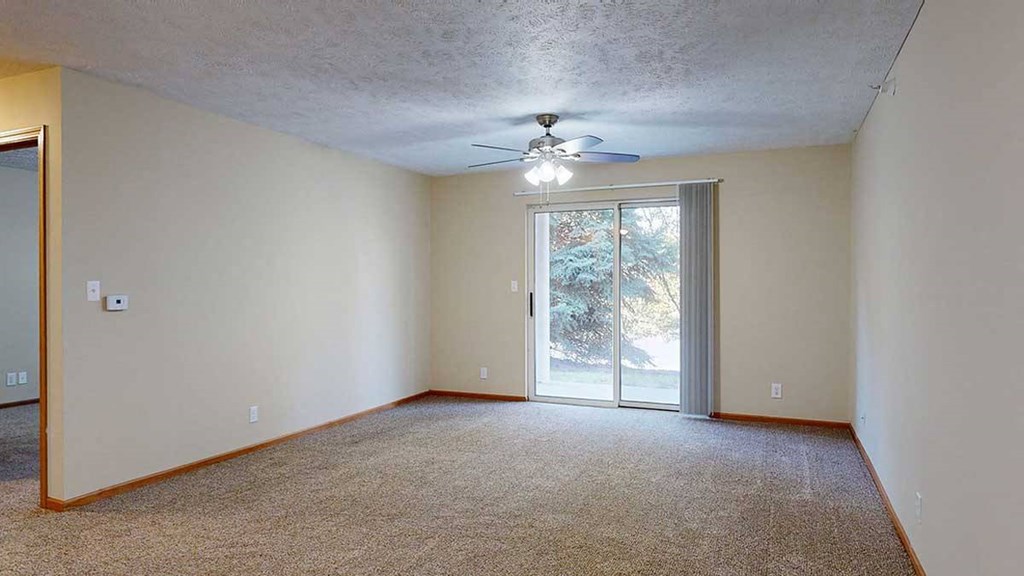 a living room with carpet, a ceiling fan, and a sliding glass door to a patio