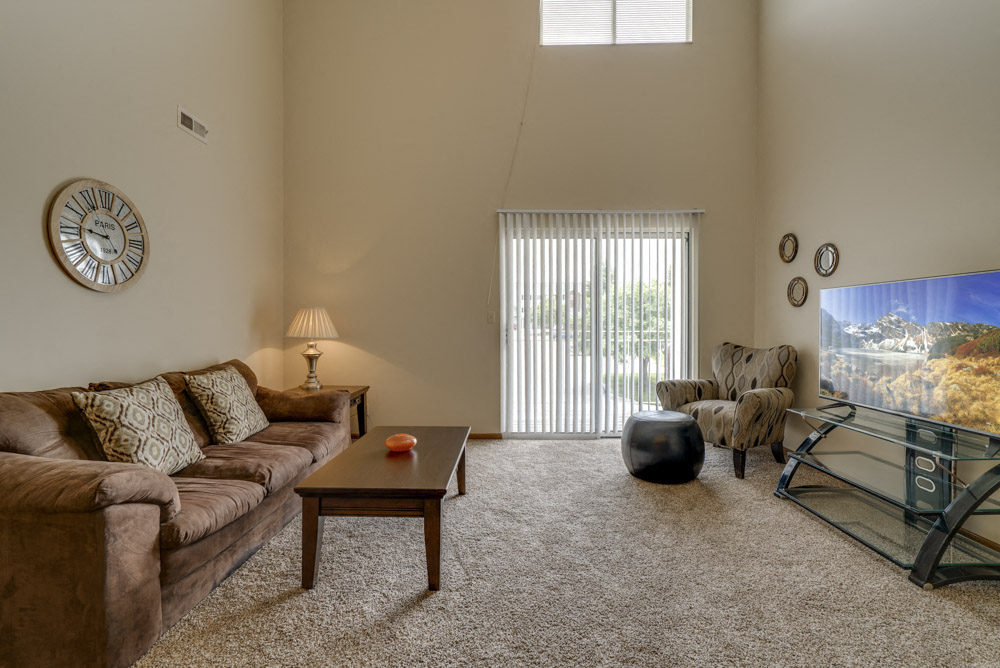 Large windows and sliding doors provide lots of natural lighting in the living space at Pine Lake Heights Apartments