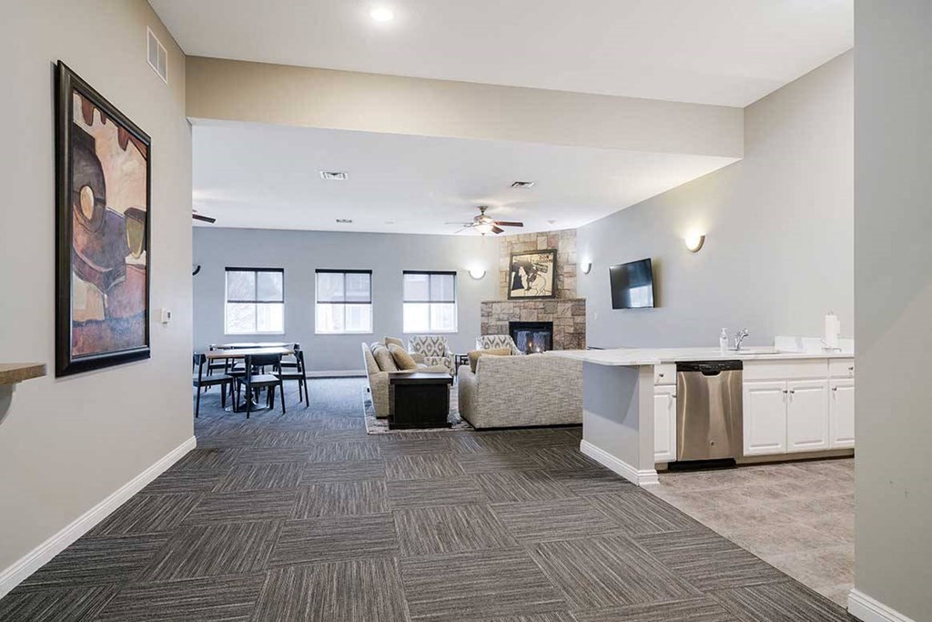 a clubhouse room with open seating areas and a kitchen