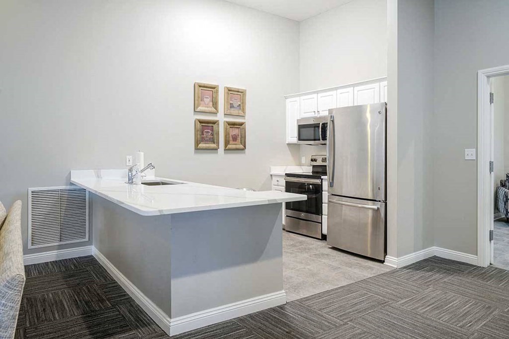a community kitchen space in the clubhouse with fridge, oven/stove, and microwave