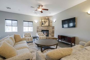 a clubhouse room with couches and a tv next to a fireplace
