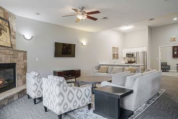 a clubhouse room with couches and a tv next to a fireplace