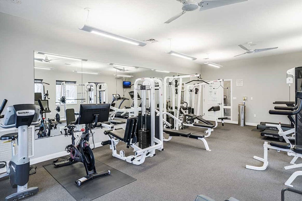 a gym with cardio equipment and weight machines