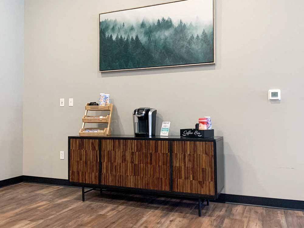 a wooden cabinet with a coffee maker bar