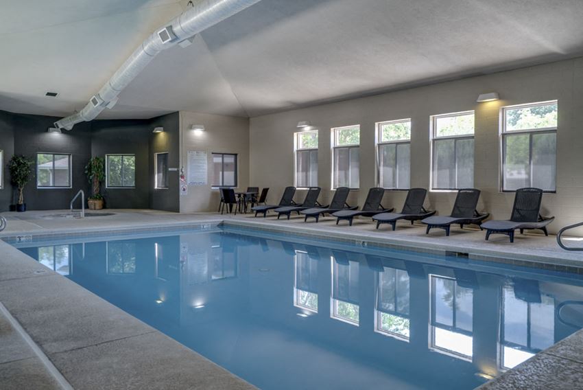 Indoor pool with lounge chairs at Pinebrook Apartments - Photo Gallery 1