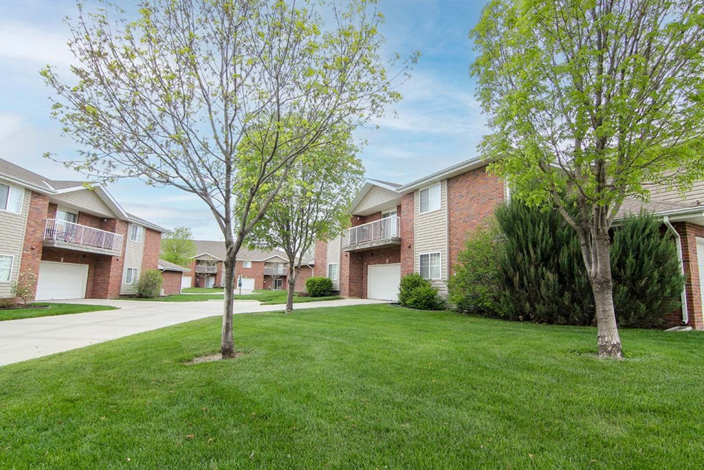 A grassy area in front of apartment buildings.