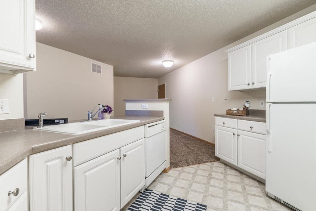A kitchen with white cabinets and appliances.