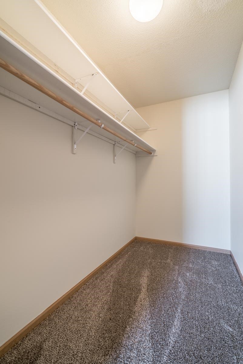 A room with a carpeted floor and a white wall.