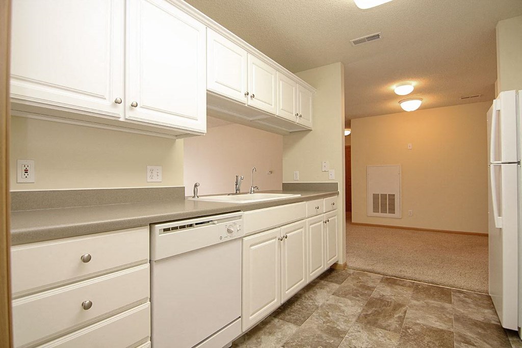 A kitchen with white cabinets and appliances.
