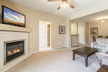 Interiors-Living room with fireplace and ceiling fan at Ridge Pointe Villas - Photo Gallery 13