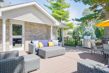 Sun deck with outdoor furniture for lounging and community grill in the back.