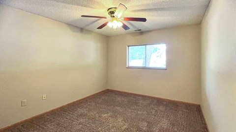 a bedroom with a ceiling fan and a window