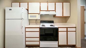 a kitchen with white white appliances and white and brown cabinets