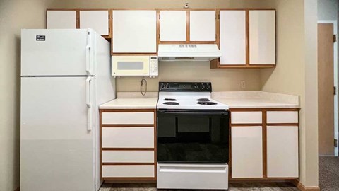 a kitchen with white white appliances and white and brown cabinets