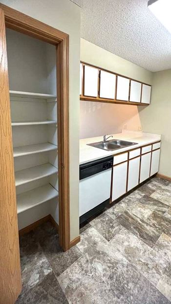 a kitchen with white and brown cabinets and a pantry