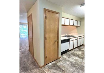 a closed kitchen pantry next to a dishwasher and cabinets