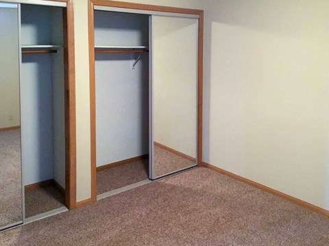 a bedroom with two closets with sliding mirror doors
